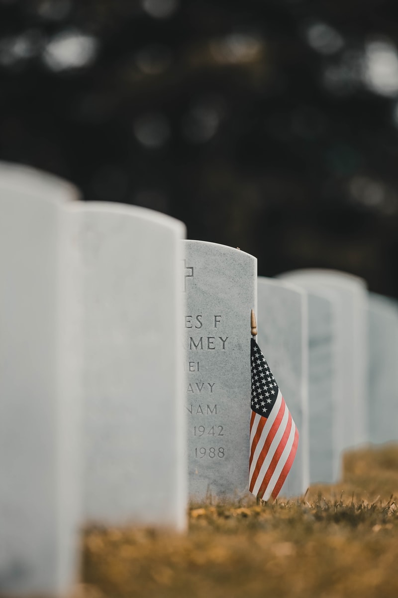 US flag leaning on headstone